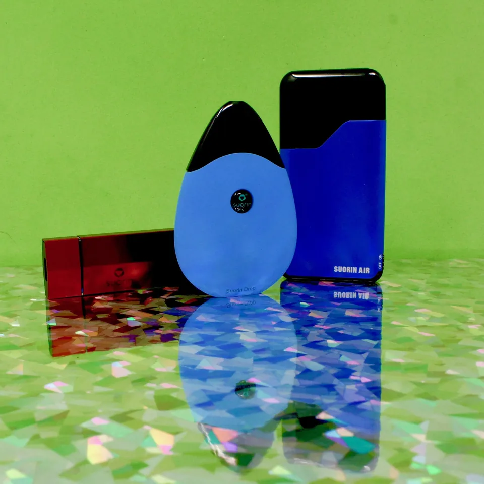 Blue and black pod vape devices on a reflective holographic surface
