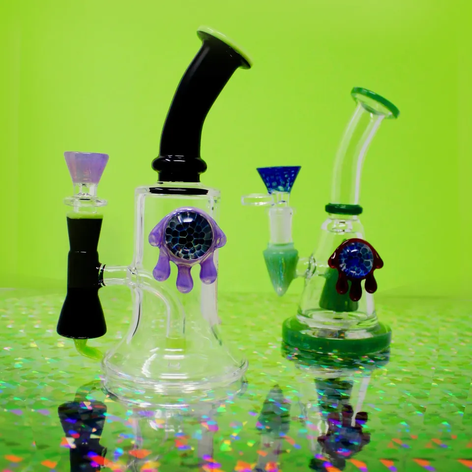 Glass water pipes with purple and green accents on a holographic surface