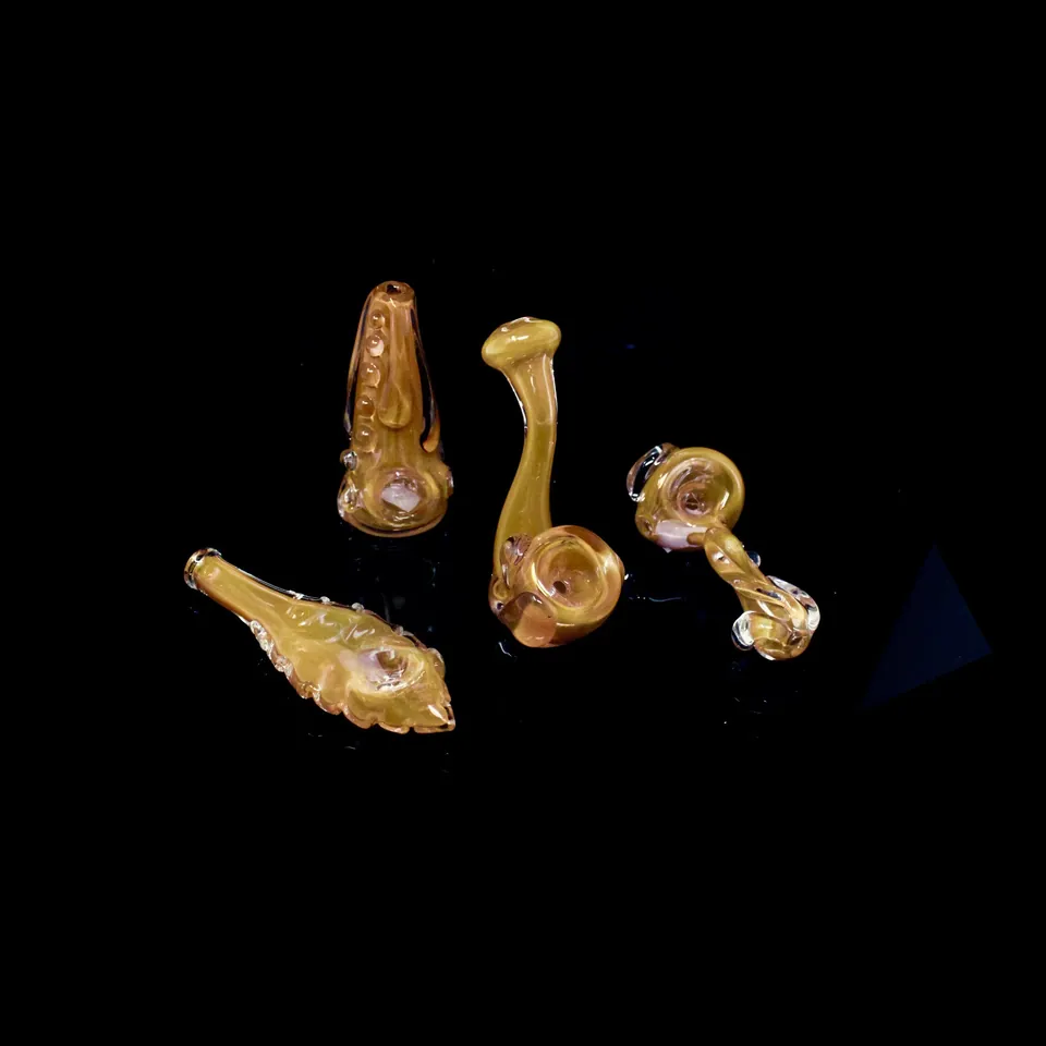Three amber and gold fumed glass spoon pipes on black
