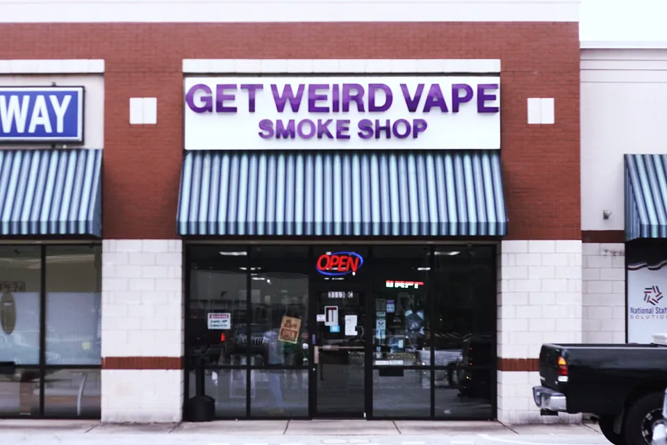 Get Weird Vape Smoke Shop storefront with striped awning on North Pleasantburg Drive